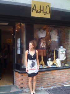 Kate in front of her store, with mannequins and clothes in the window
