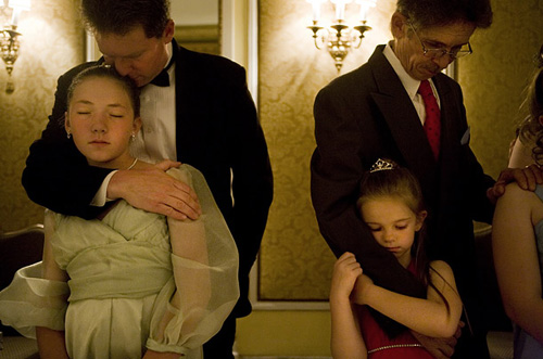 Fathers hug their daughters from behind at a Purity Ball