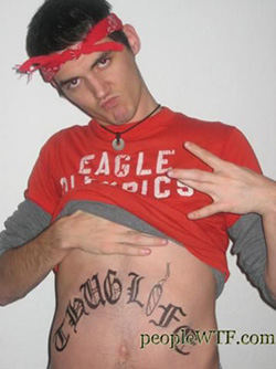 White boy lifting up his shirt to show a Thuglife tattoo and representing East coast