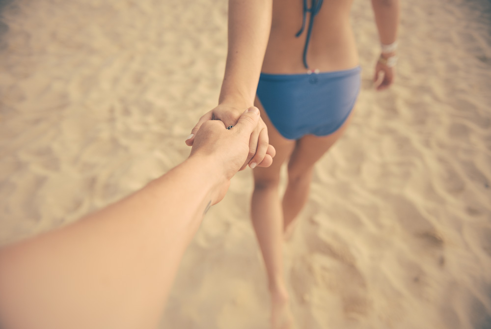 lovers holding hands on beach