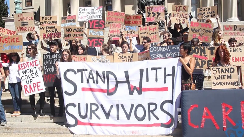 protestors with stand with survivors sign