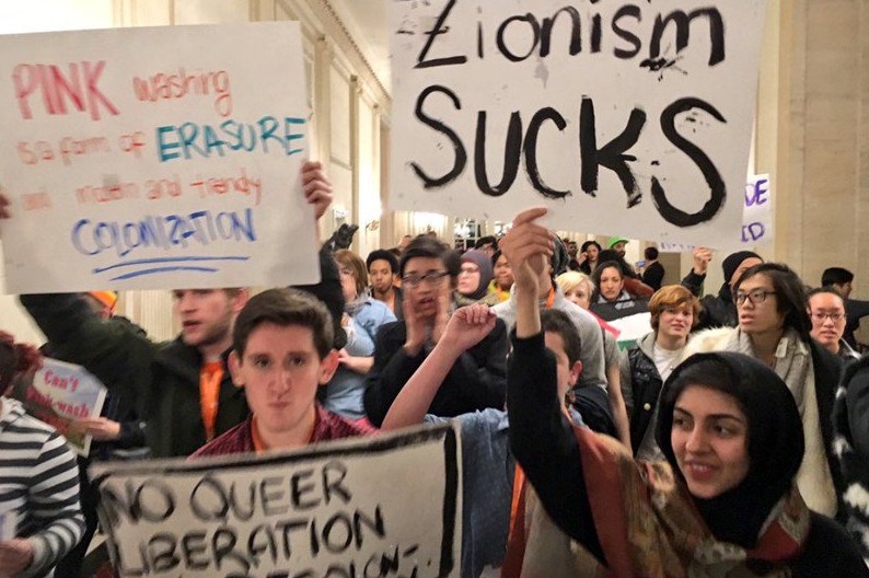 Protesters hold a sign saying "zionism sucks" at a Creating Change Conference in Chicago.