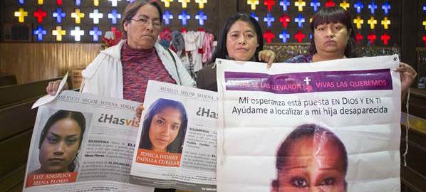 Three women hold photos of their daughters, disappeared in Juarez.