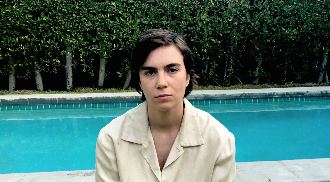 Grace Dunham in front of a pool, facing the camera