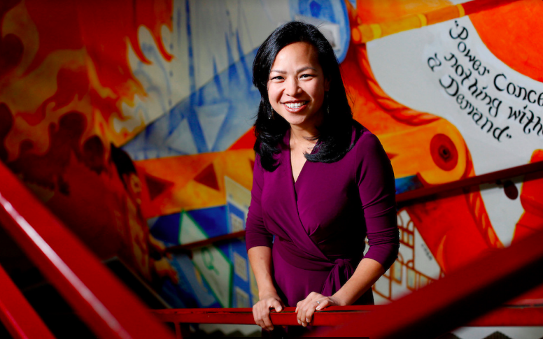 Vien Truong smiling in front of a red railing