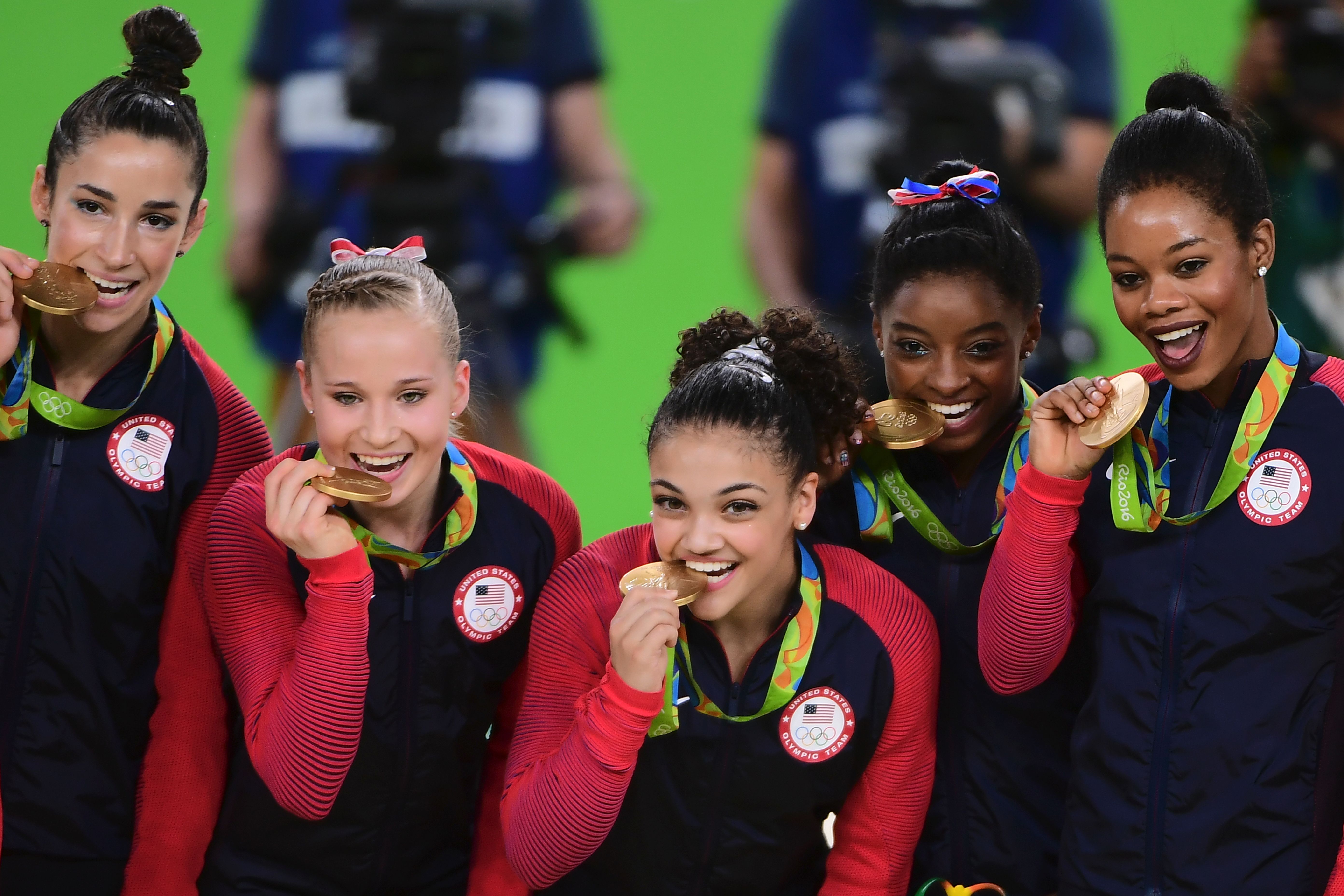 US gymnasts Alexandra Raisman, Madison Kocian, Lauren Hernandez, Simone Biles and Gabrielle Douglas celebrate with their gold medals on the podium during the women's team final Artistic Gymnastics at the Olympic Arena during the Rio 2016 Olympic Games in Rio de Janeiro on August 9, 2016. Photo Credit: EMMANUEL DUNAND/AFP/Getty Images.