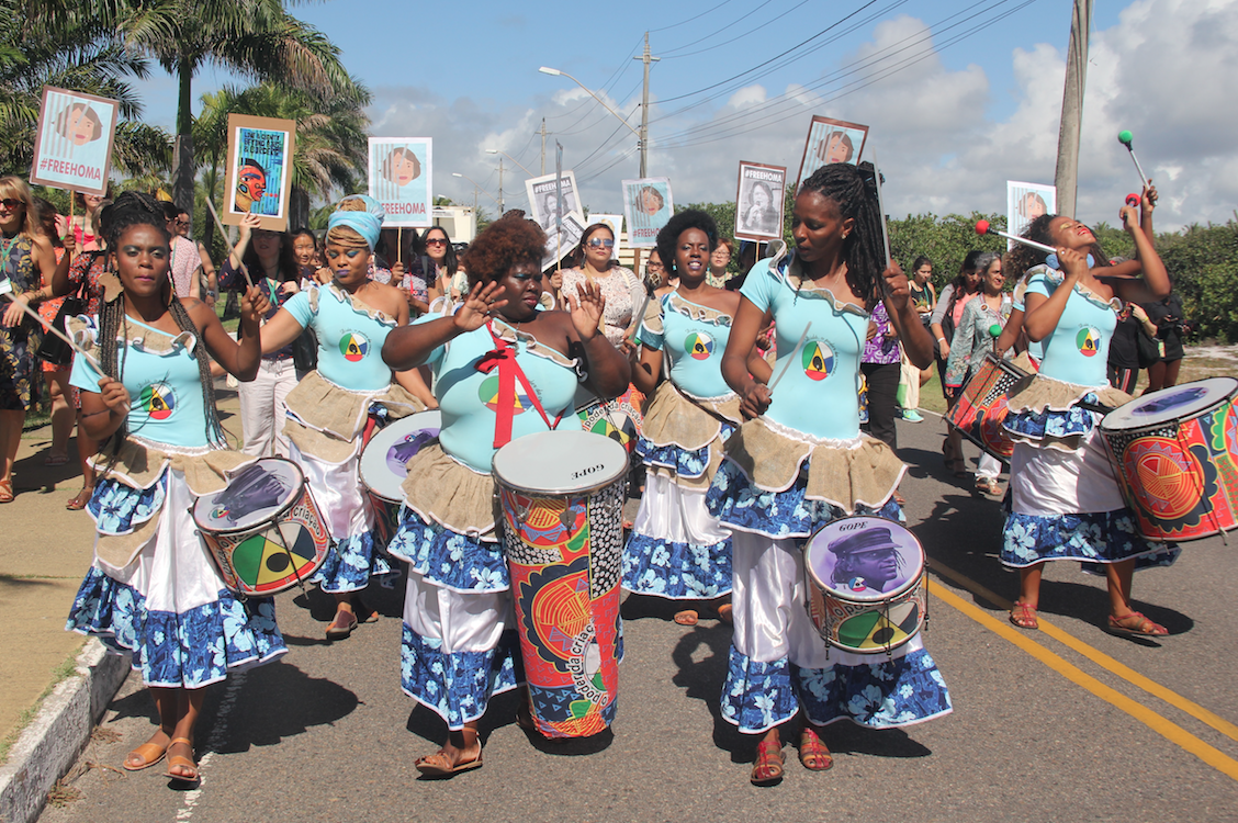 Black women march in the street with African drums