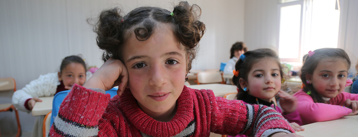 Girls looking into the camera at an education center in Syria