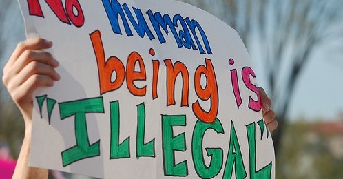Sign reads "No Human being is illegal"