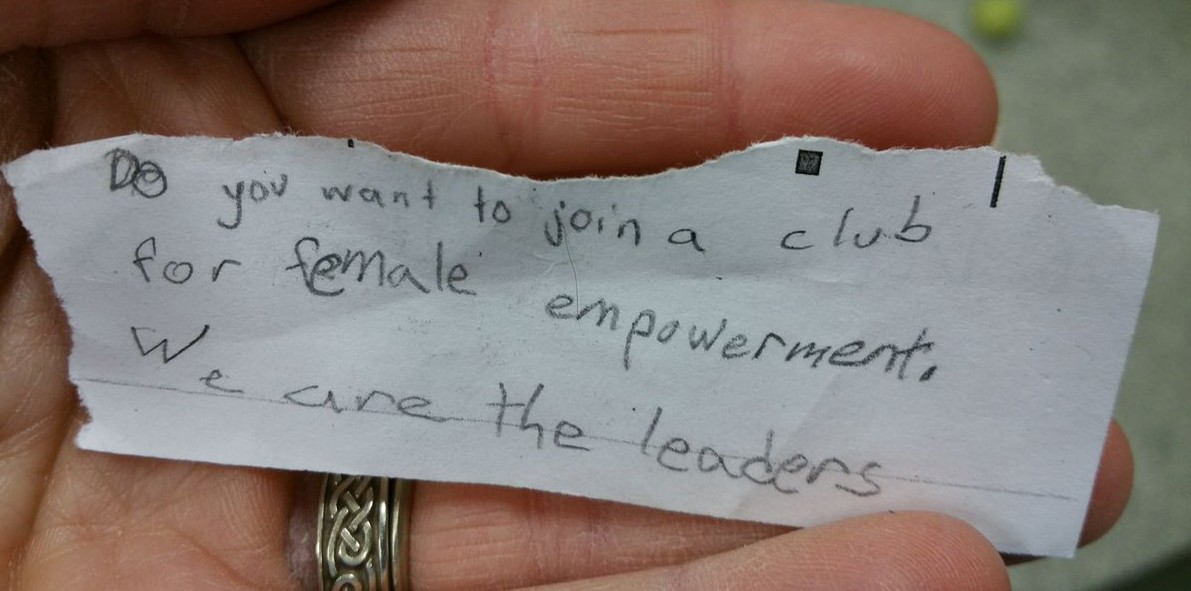 A piece of paper with "Do you want to join a club for female empowerment. We are the leaders" written on it.