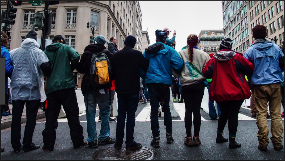 People link arms in a row at a protest.