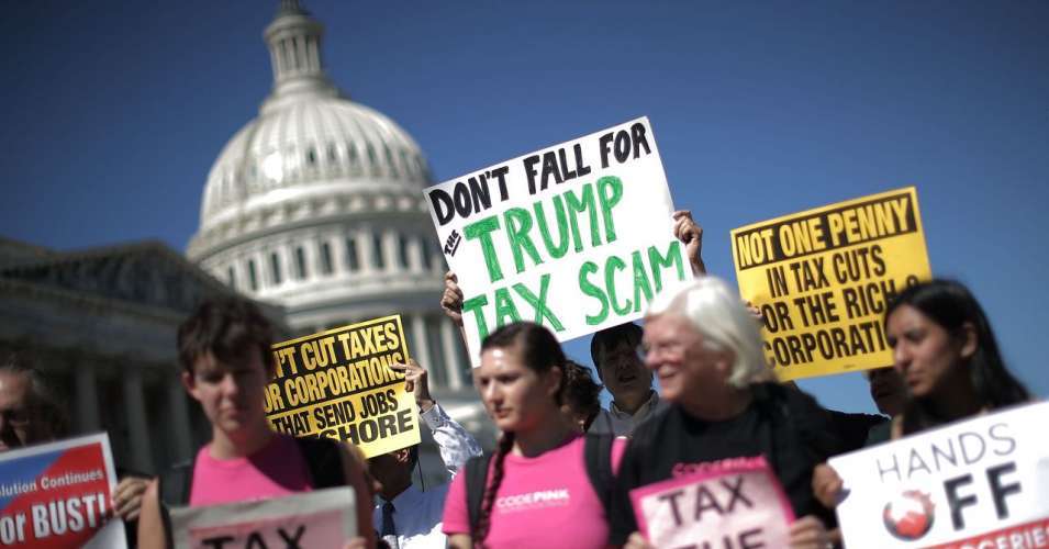 People protest the Republican tax scam outside the U.S. Capitol.