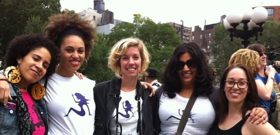 The crew wearing Feministing t shirts smiling at a protest