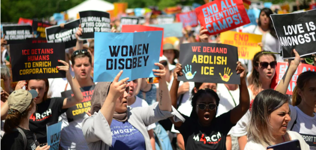 Image of protesters holding signs saying "abolish ice".