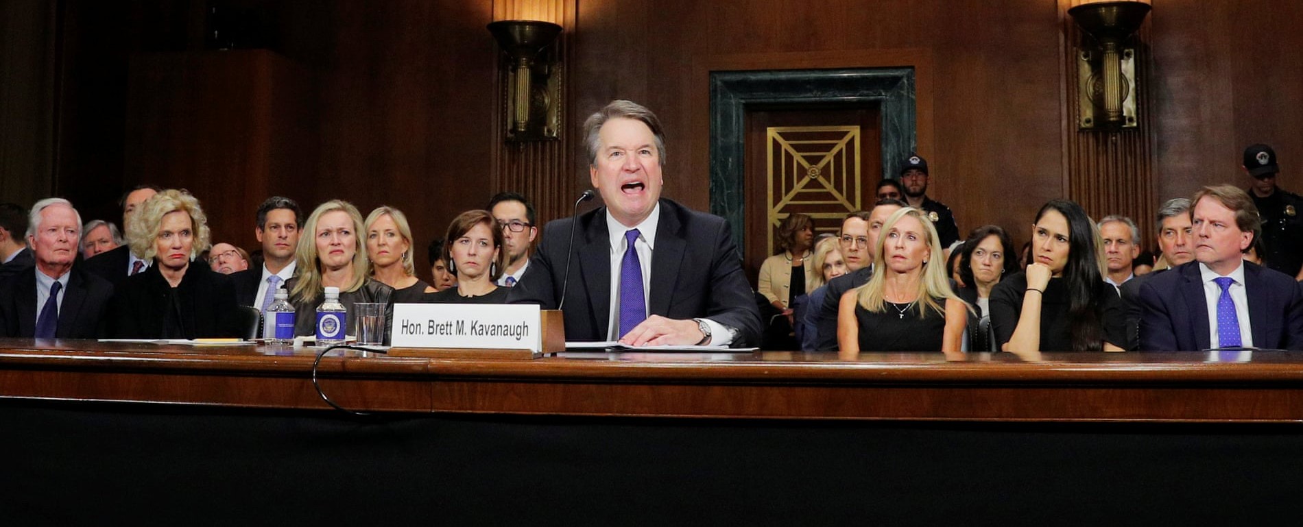 Kavanaugh looking angry while scowling women look on